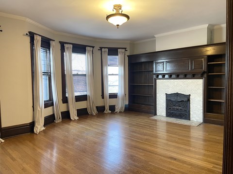 A room with a fireplace and wooden floors.